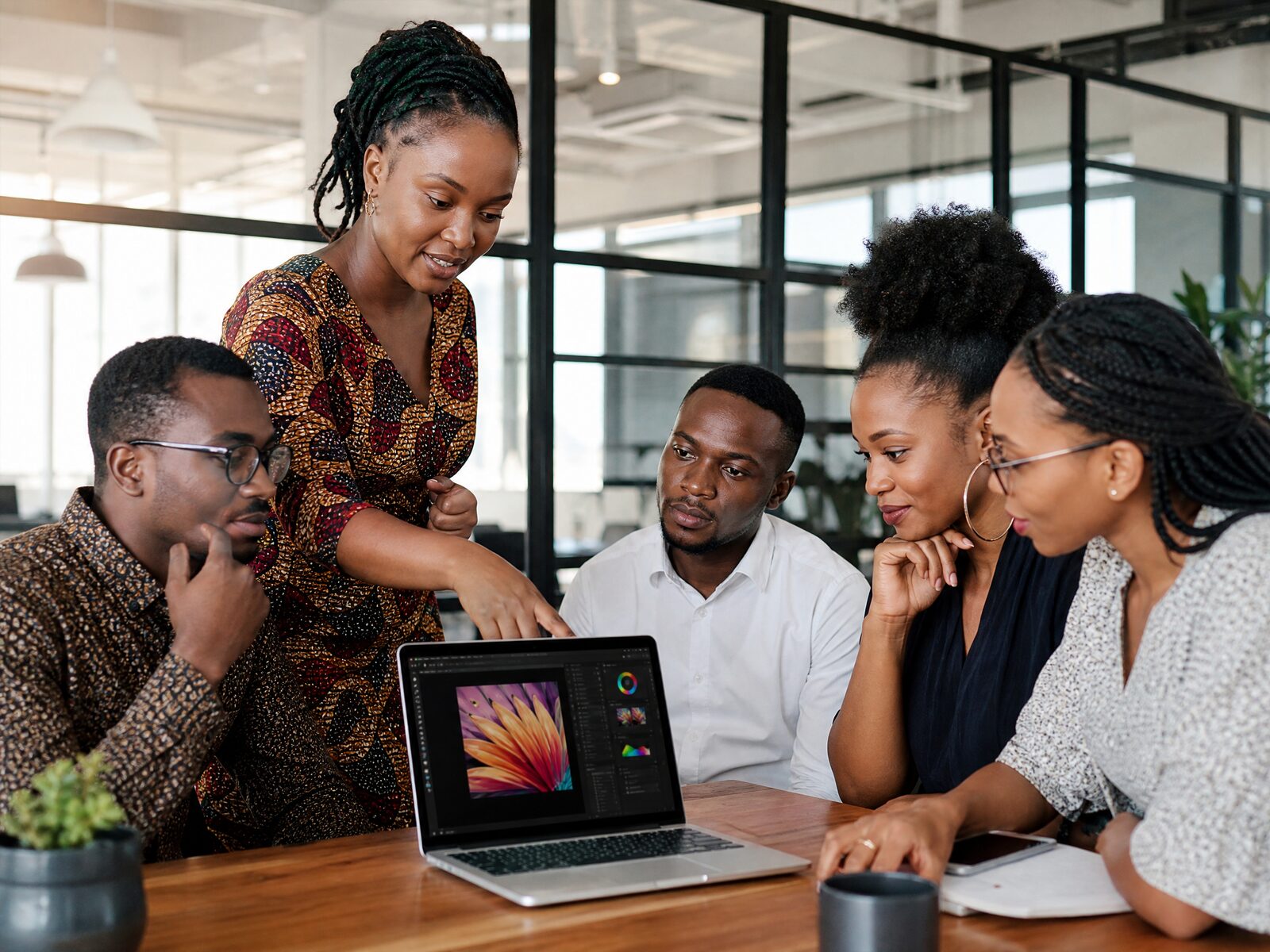 Équipe pluridisciplinaire de TechGundy Academy collaborant autour d'un ordinateur portable pendant une session de formation aux compétences numériques